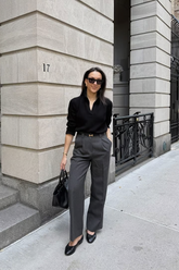 a lady in a black shirt and a pair of grey pants